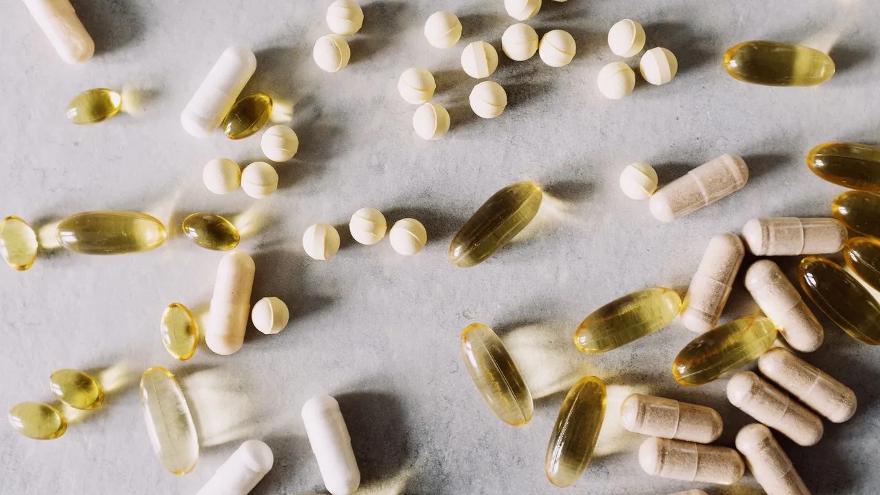 Top view of scattered set of pills and dietary supplements to prevent lack of vitamins on table in light studio
