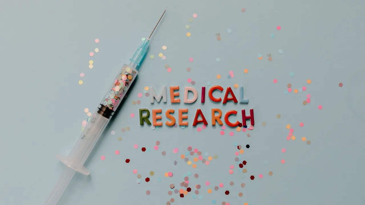 Close-up of a syringe with colorful confetti on medical research theme.