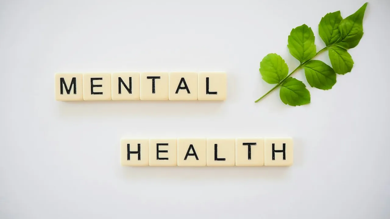 the word mental health spelled with scrabbles next to a green leaf
