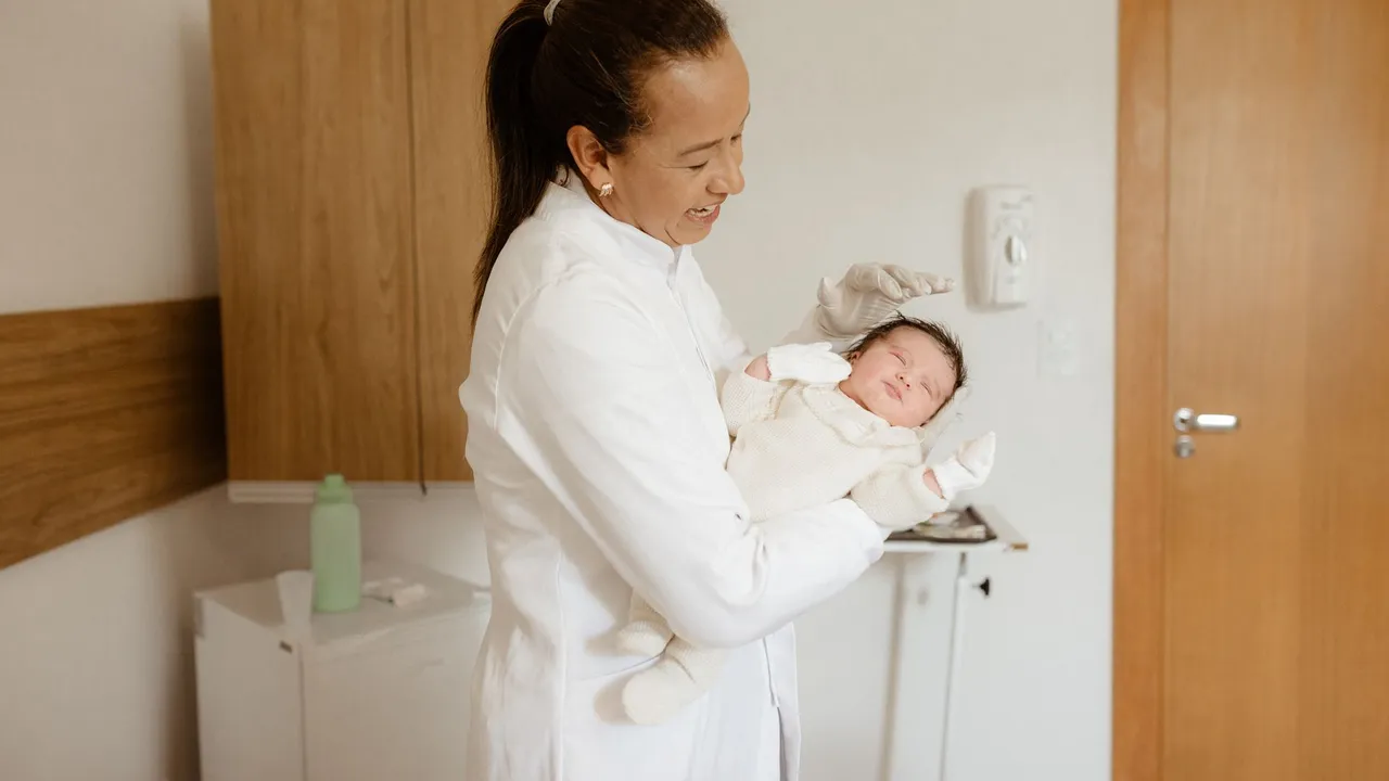 A medical practitioner gently holding a newborn baby in a hospital room, symbolizing care and health.