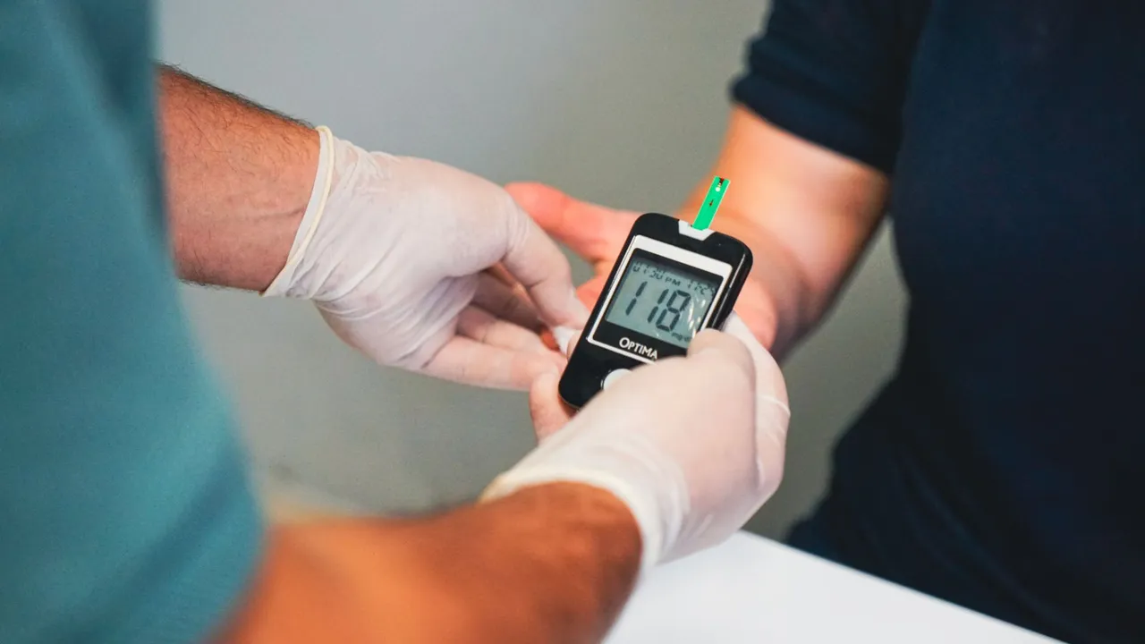 Healthcare professional using glucometer to check blood sugar level, indicating diabetes management.