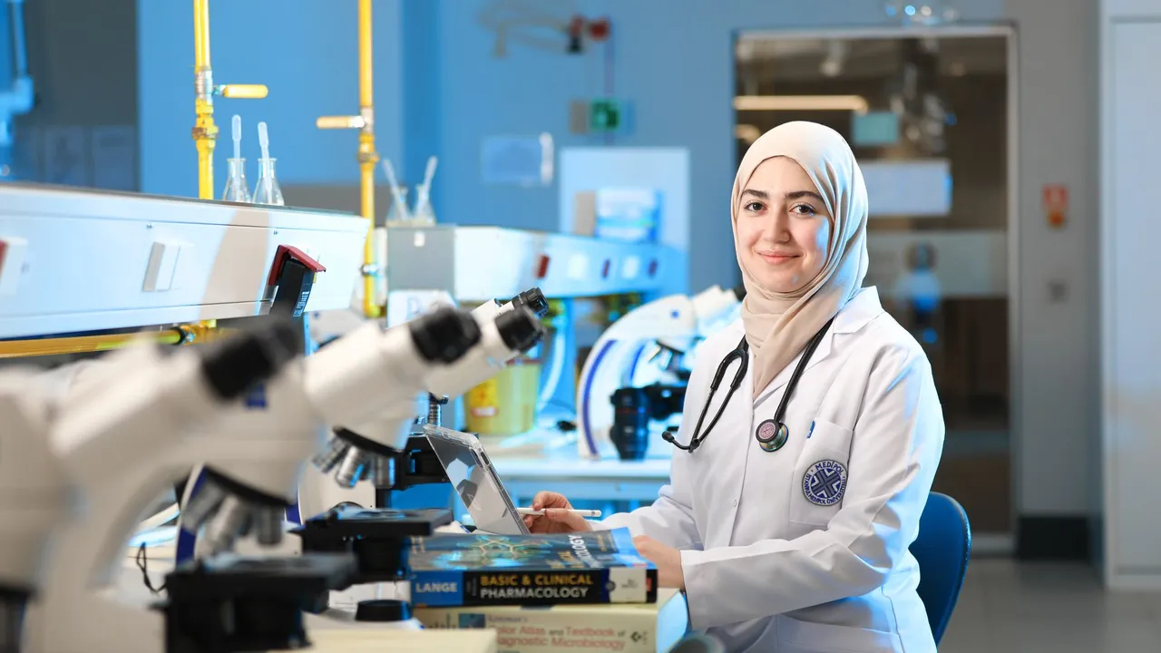 A female scientist in a laboratory setting, conducting research with microscopes and reference books.