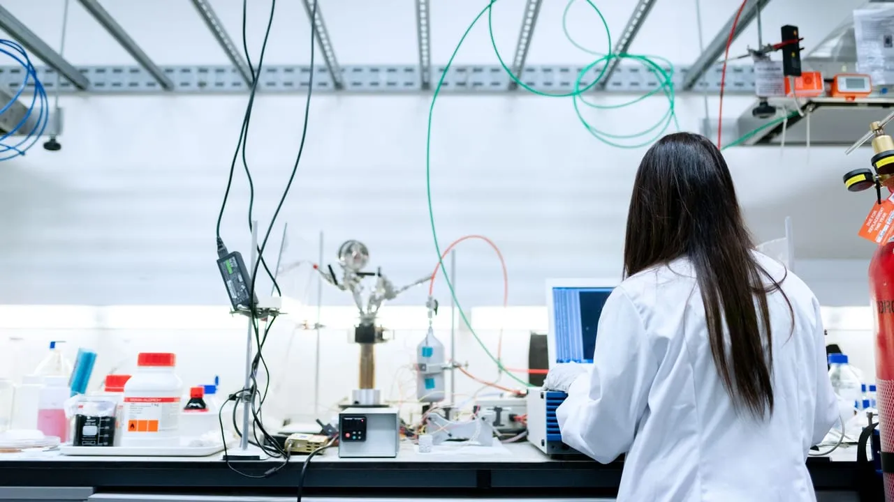 A female scientist conducting research in a contemporary laboratory full of equipment.
