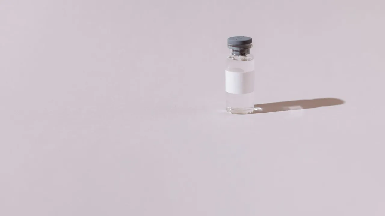 A sterile vaccine vial isolated on a minimalist gray background, emphasizing health and medicine.