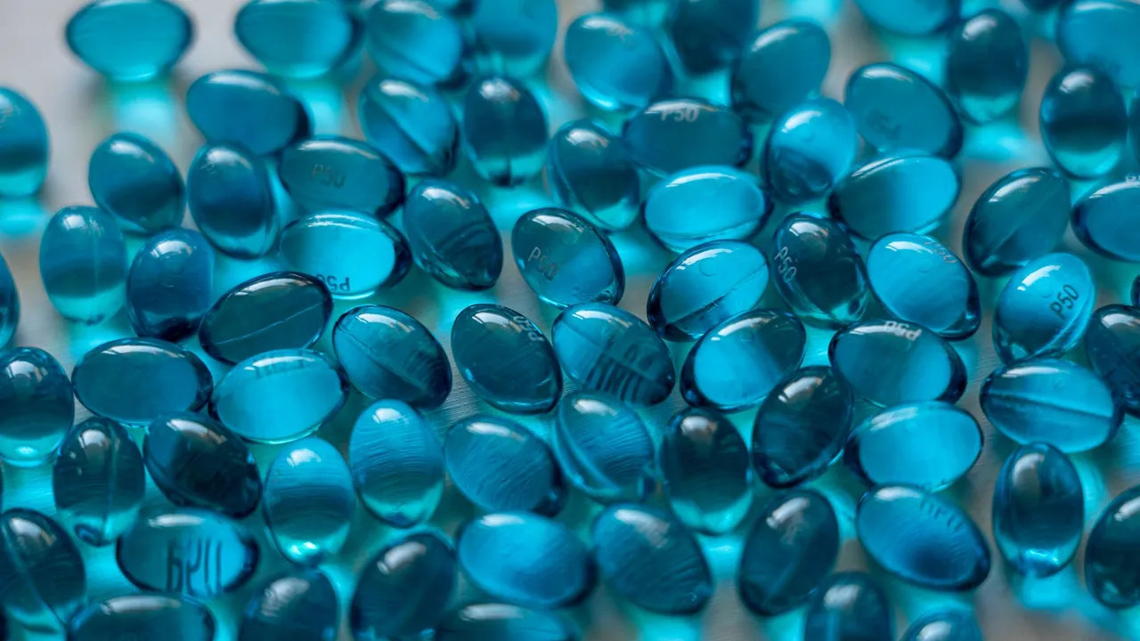 Detailed close-up of vibrant blue gel capsules symbolizing medical and healthcare treatments.
