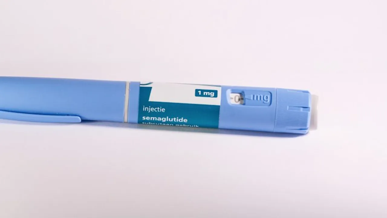 A blue insulin pen rests on a white surface