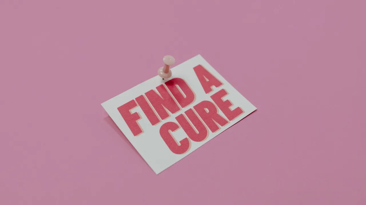 A pink note pinned with message 'Find a Cure', symbolizing cancer awareness.