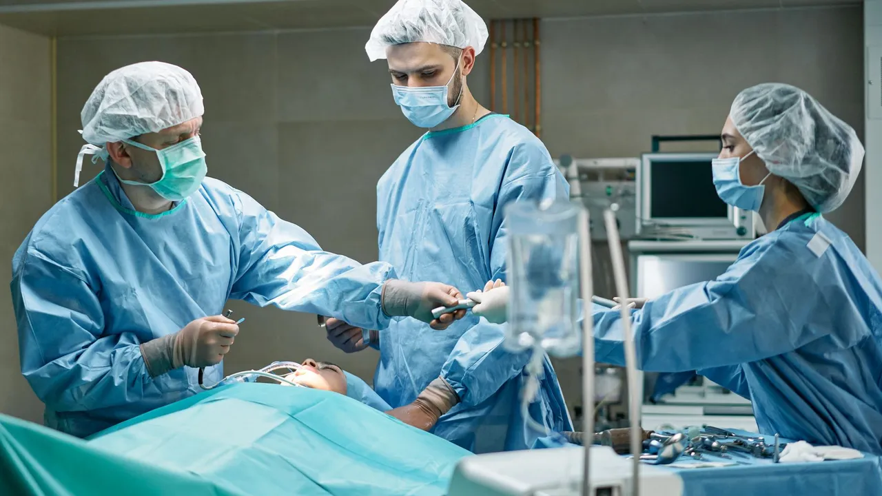 Medical team performing surgery in well-equipped operating room with focus.