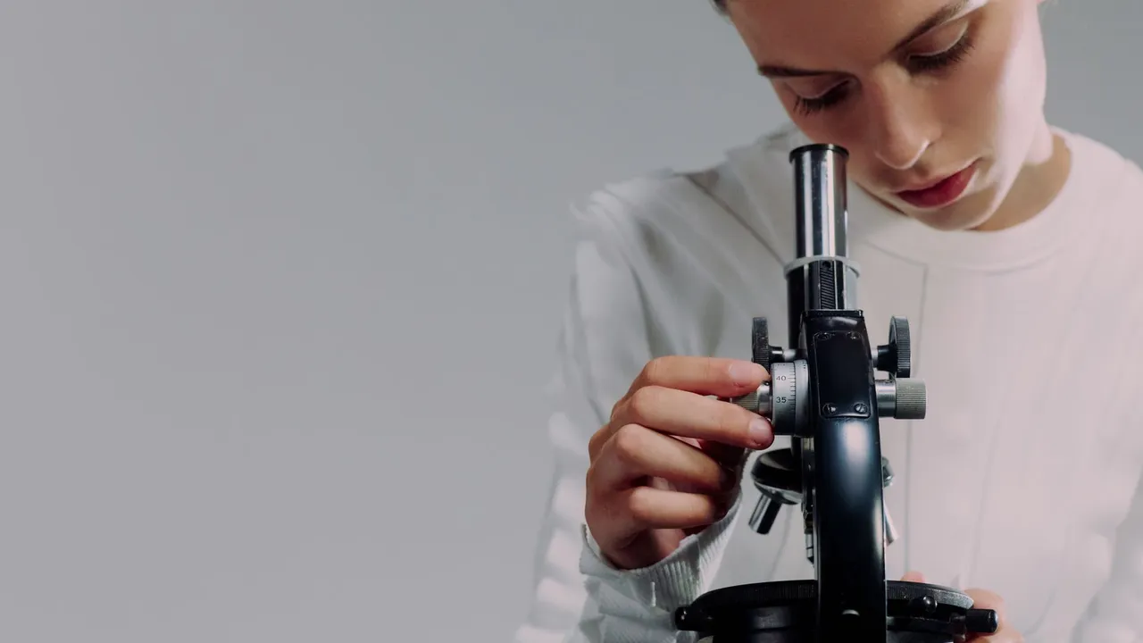 A scientist carefully examining samples using a microscope in a modern laboratory setting.