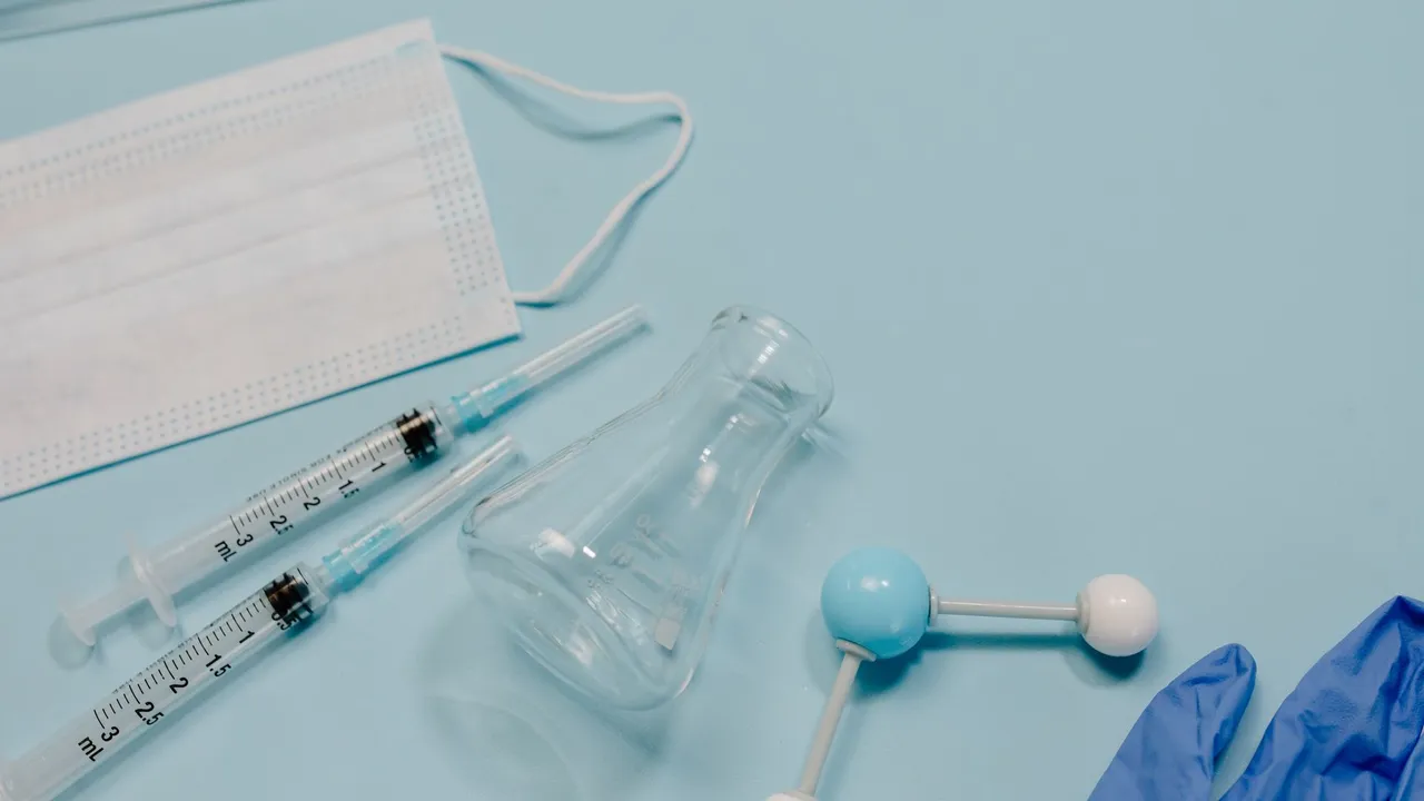 A collection of medical tools including syringes, face mask, and gloves on a blue background.