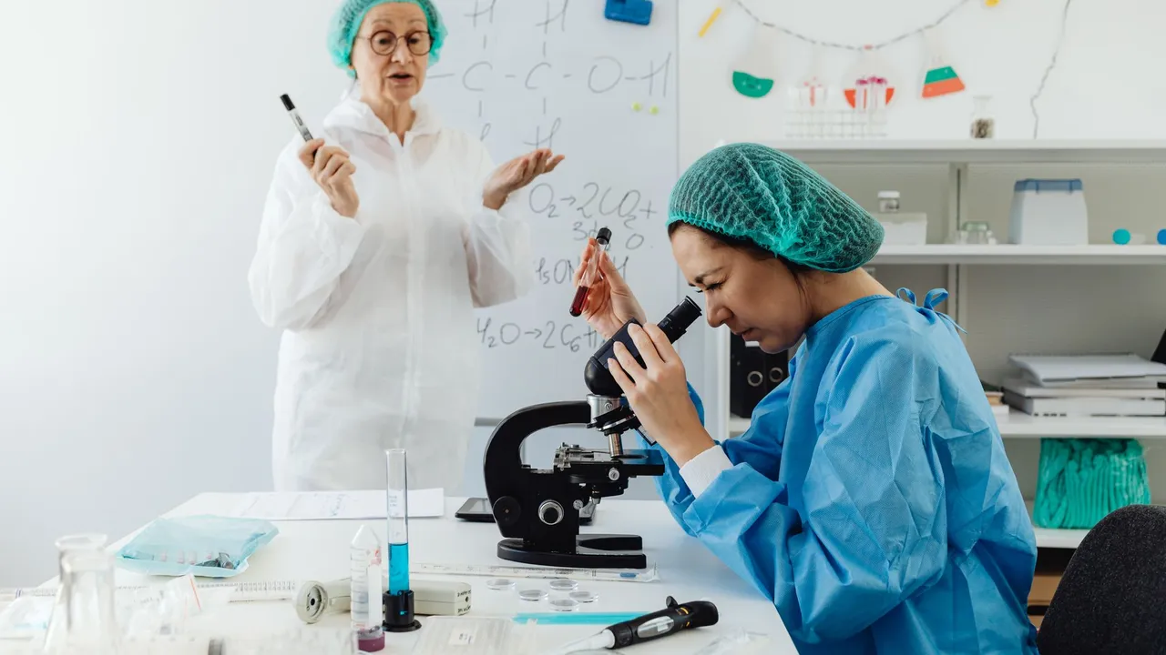Two female scientists conducting research with microscope in a laboratory setting.