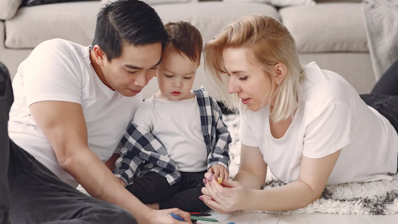 Loving family creating art together, fostering play and connection indoors.