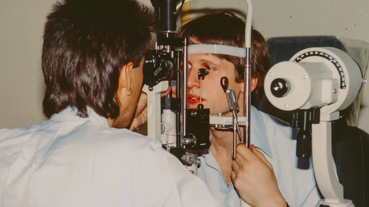 Optometrist examining a patient's eye with equipment.