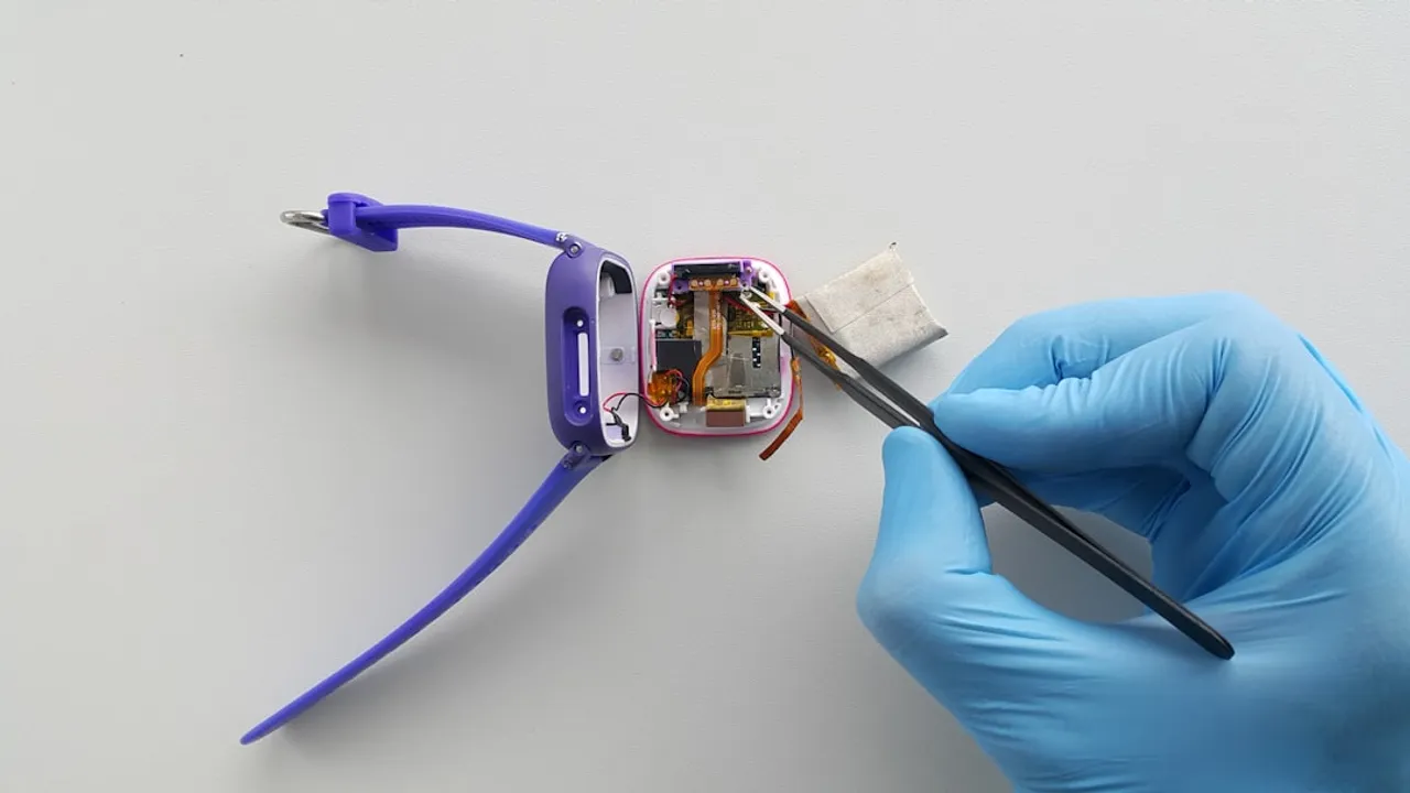 a person in blue gloves is removing a broken cell phone