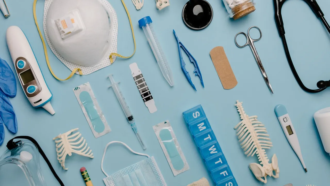 A comprehensive flat lay of diverse medical supplies including PPE and diagnostic equipment on a blue surface.