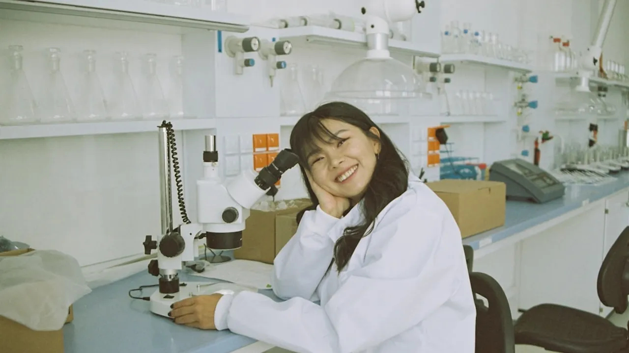 woman in white laboratory gown holding black microphone