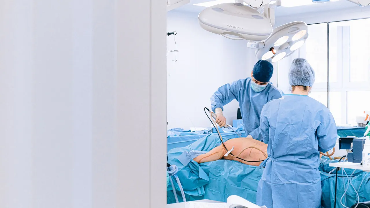 Two surgeons in a sterile operating room performing surgery on a patient.