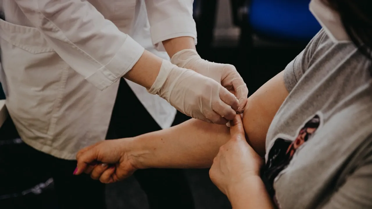 person in white long sleeve shirt holding babys hand