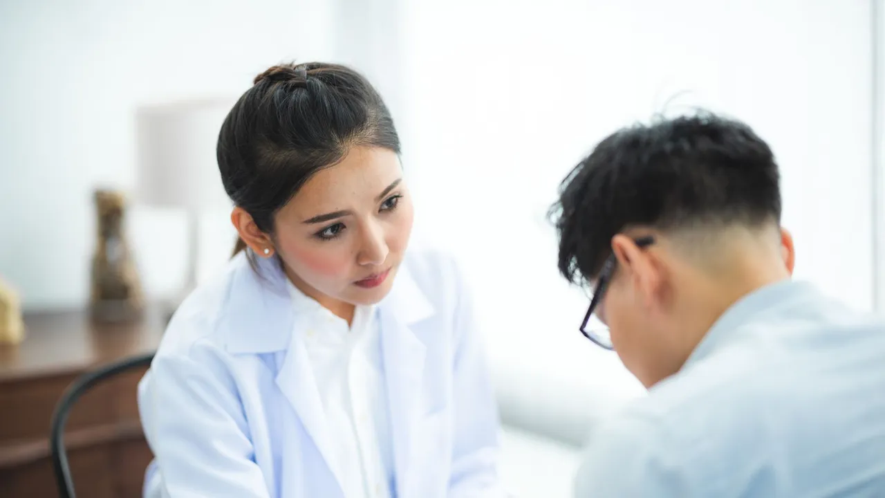 A doctor attentively listens to a patient during a medical consultation, emphasizing care and understanding.
