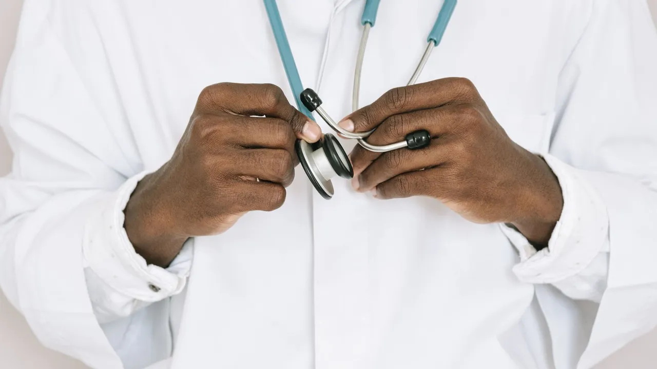 A professional doctor holding a stethoscope, focusing on hands and medical tools.