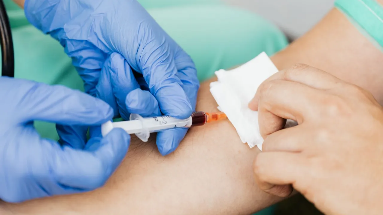 Close-up of a healthcare professional taking a blood sample using a syringe and gloves.
