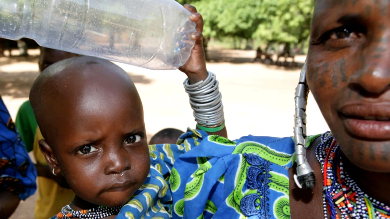 A young child waits with her mother for a checkup by U.S. Air Force medics and Beninese army doctors during a medical civic assistance program being conducted a