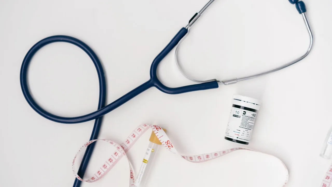 Flat lay of medical tools including stethoscope and measuring tape on a white background.