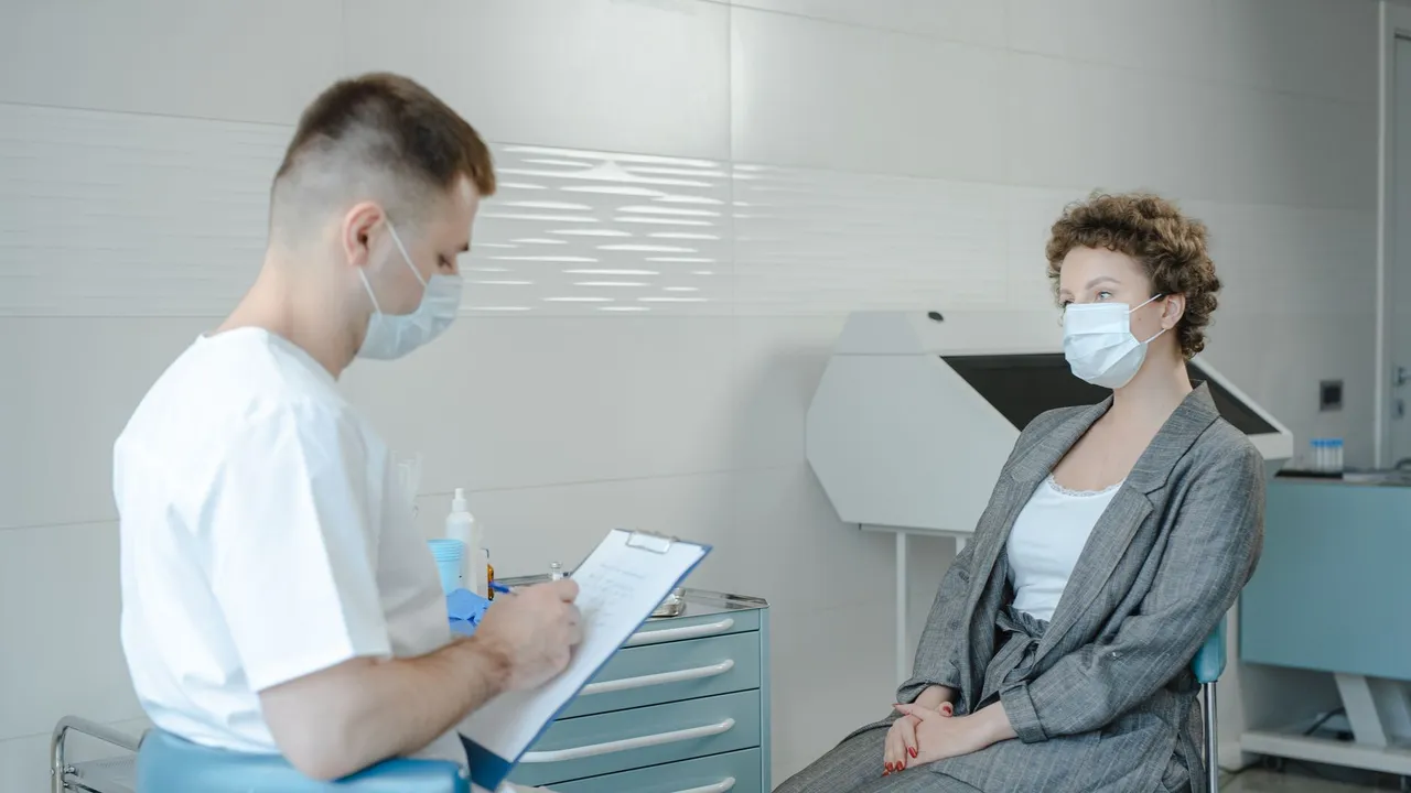 A doctor in a face mask consults a patient in a clinic, reflecting the new normal.