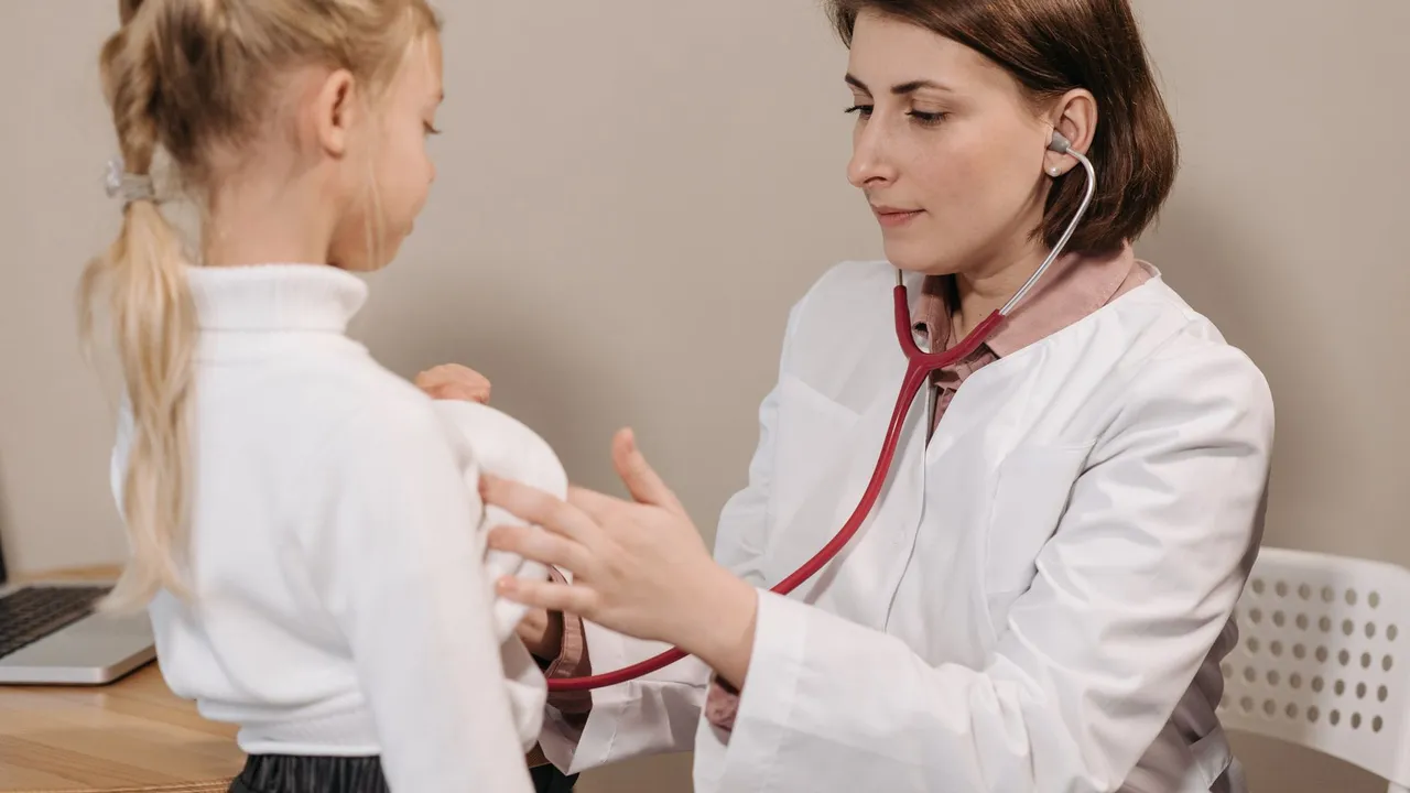 Doctor performing a health check-up on a child using a stethoscope in a clinic setting.