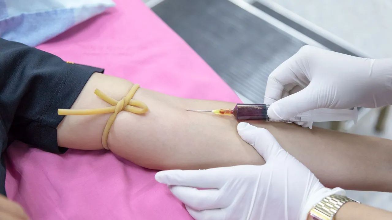 A medical professional takes a blood sample from a patient for testing.