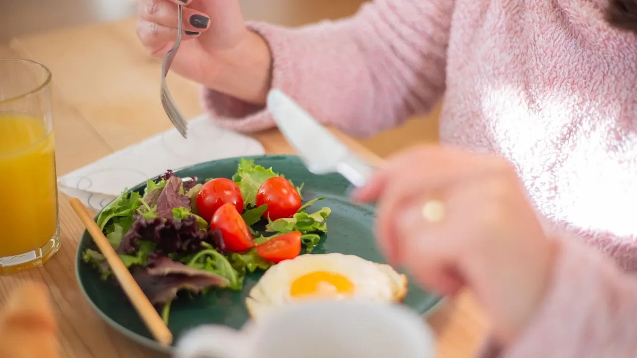Enjoy a nutritious breakfast with greens, fried egg, and fresh orange juice for a healthy start to your day.