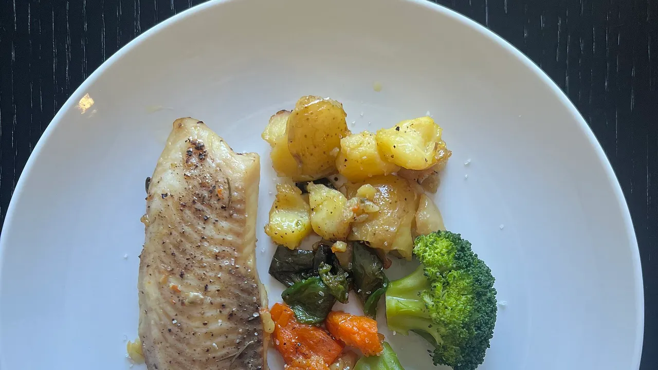 High-quality photograph by Liat Portal showing a home-cooked healthy meal prepared by Liat Portal featuring pan-seared fish served with potatoes, broccoli, carr