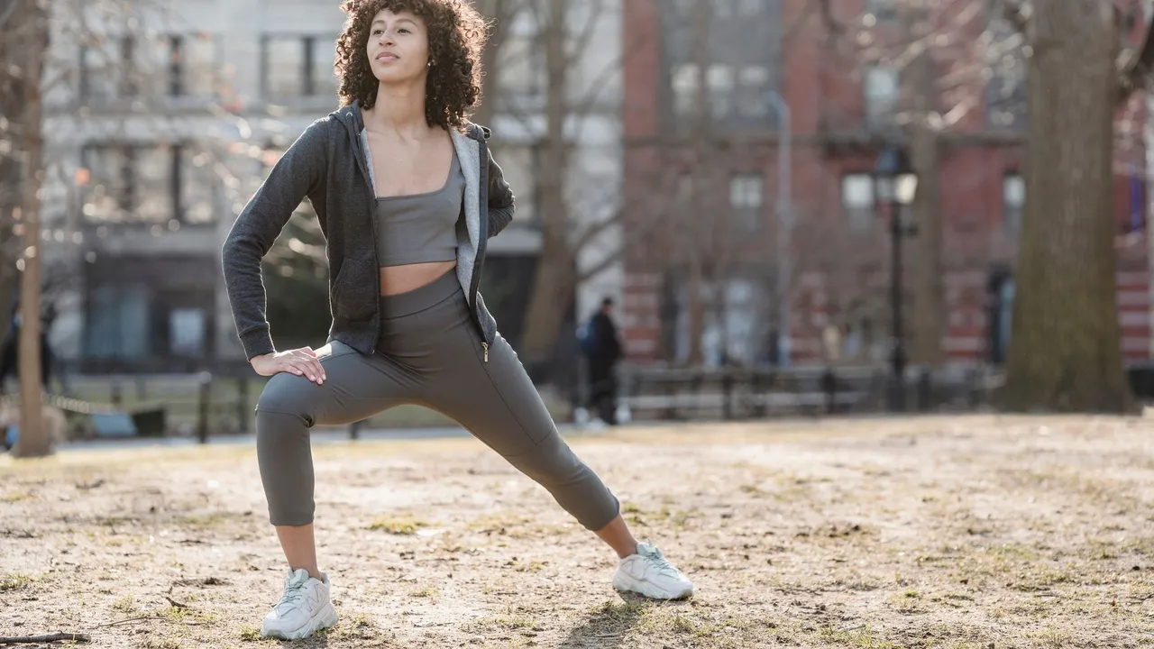 woman standing surrounded by exercise equipment