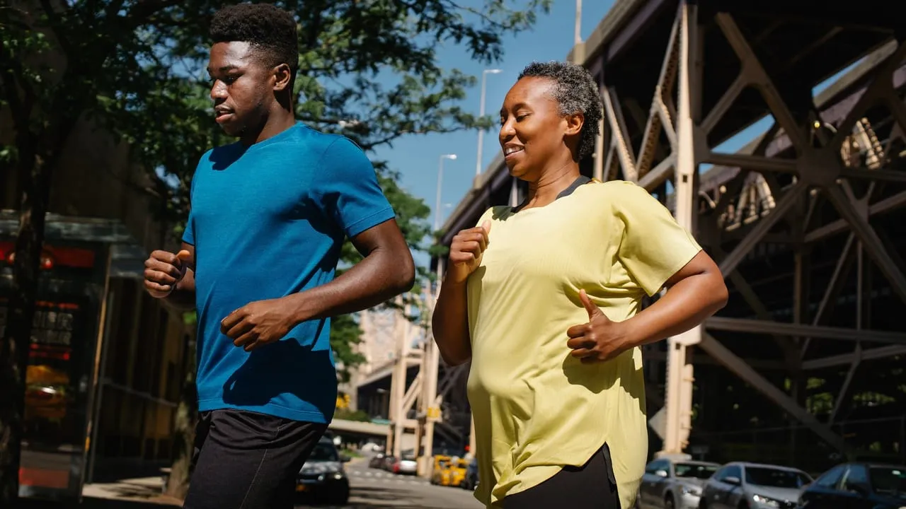A man and woman jogging outdoors on a sunny day, embracing an active lifestyle.