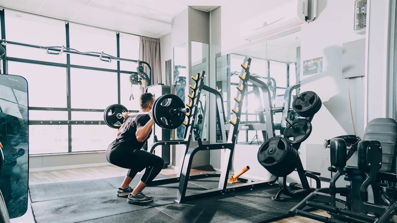 woman in black shirt and blue denim jeans sitting on black exercise equipment