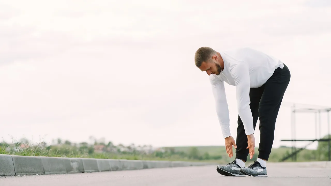 Healthy lifestyle concept with a man stretching outside in activewear, preparing for exercise.