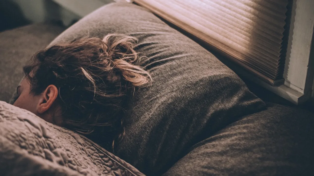 woman sleeping on bed under blankets