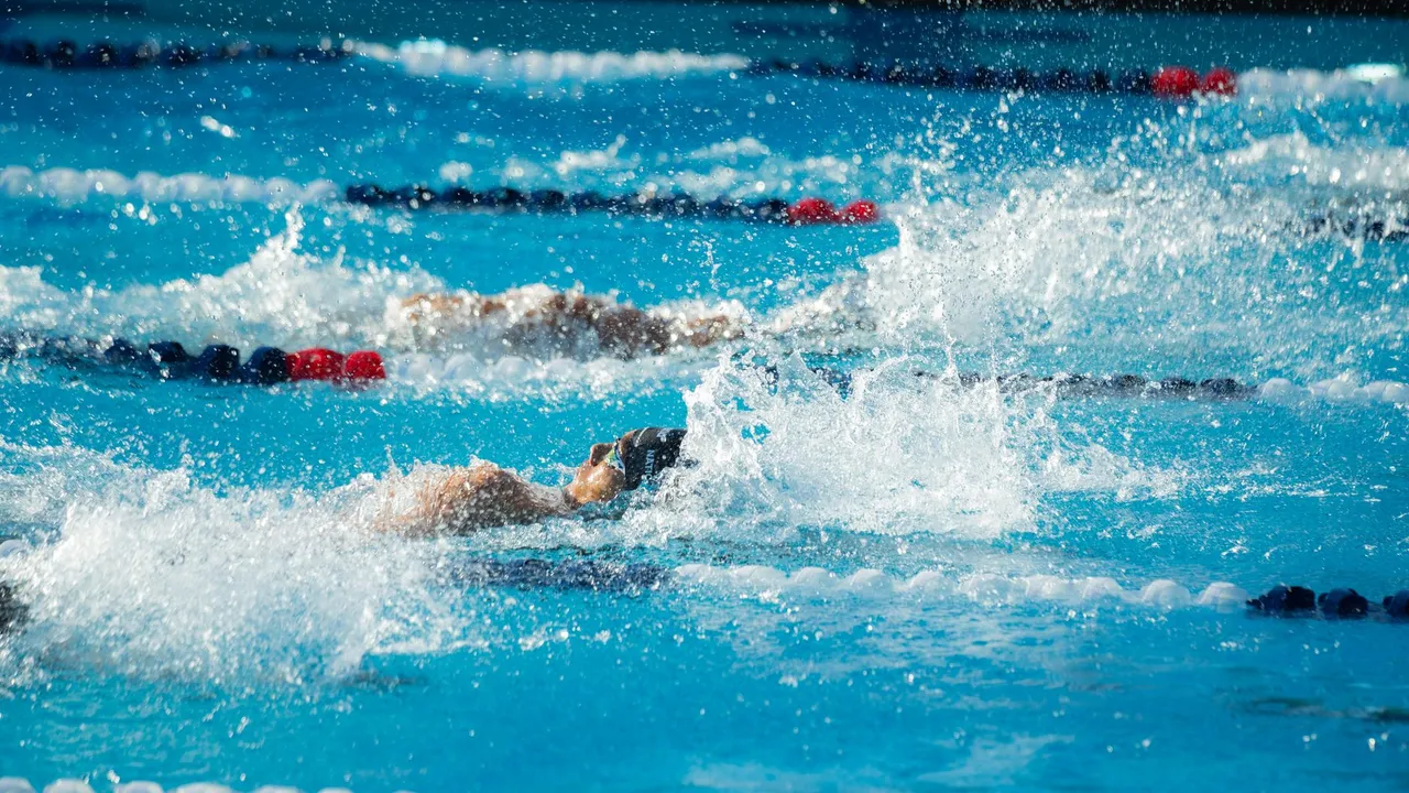 Intense swimming race moment captured with athletes in action in a pool setting.