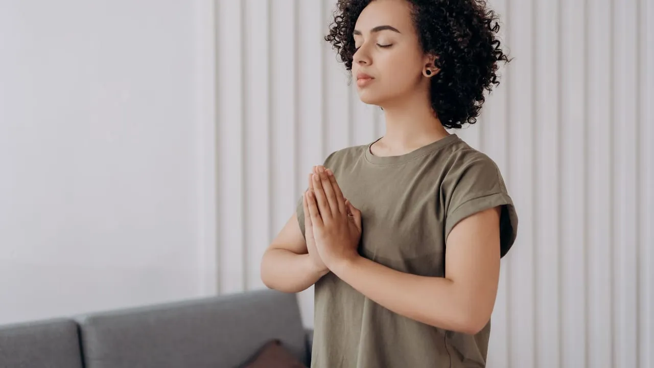 Young woman meditating indoors, practicing mindfulness and relaxation. Peaceful and serene atmosphere.