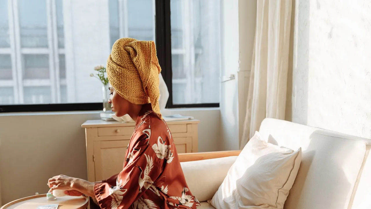 Woman enjoying a peaceful morning with warm sunlight, coffee, and a cozy interior.