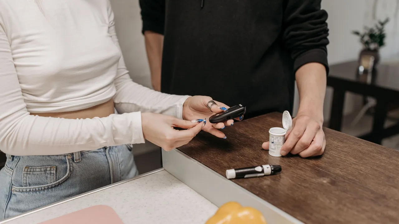 Two adults checking blood sugar with a glucometer and insulin pen on a wooden table.
